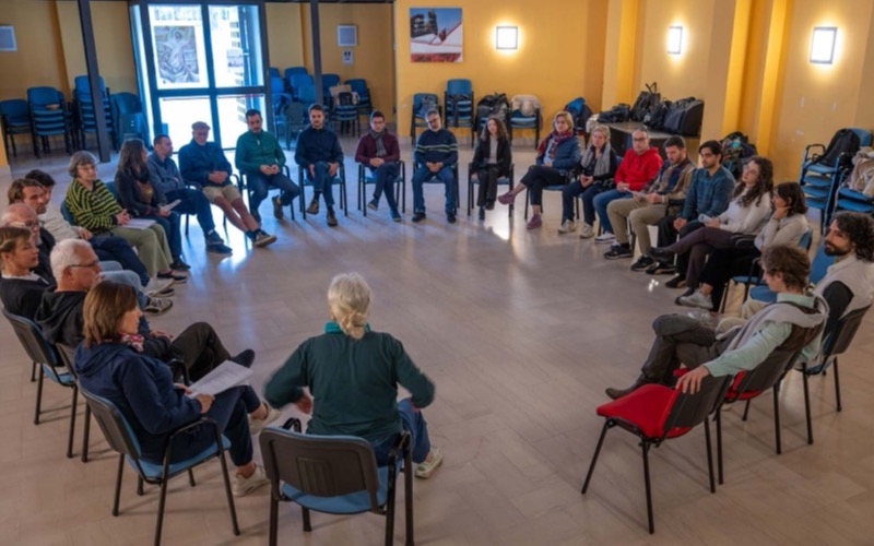Ensaio do grupo do Antigo Novo Método, atores sentados em roda numa sala de ensaio.